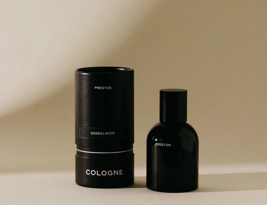 Preston Cologne in Sandalwood, a matte black bottle beside its black cylinder box