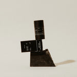 Preston Sunscreen Stick SPF 50 and its box balanced on a dark stone