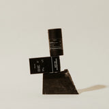 Preston Sunscreen Stick SPF 50 and its box balanced on a dark stone