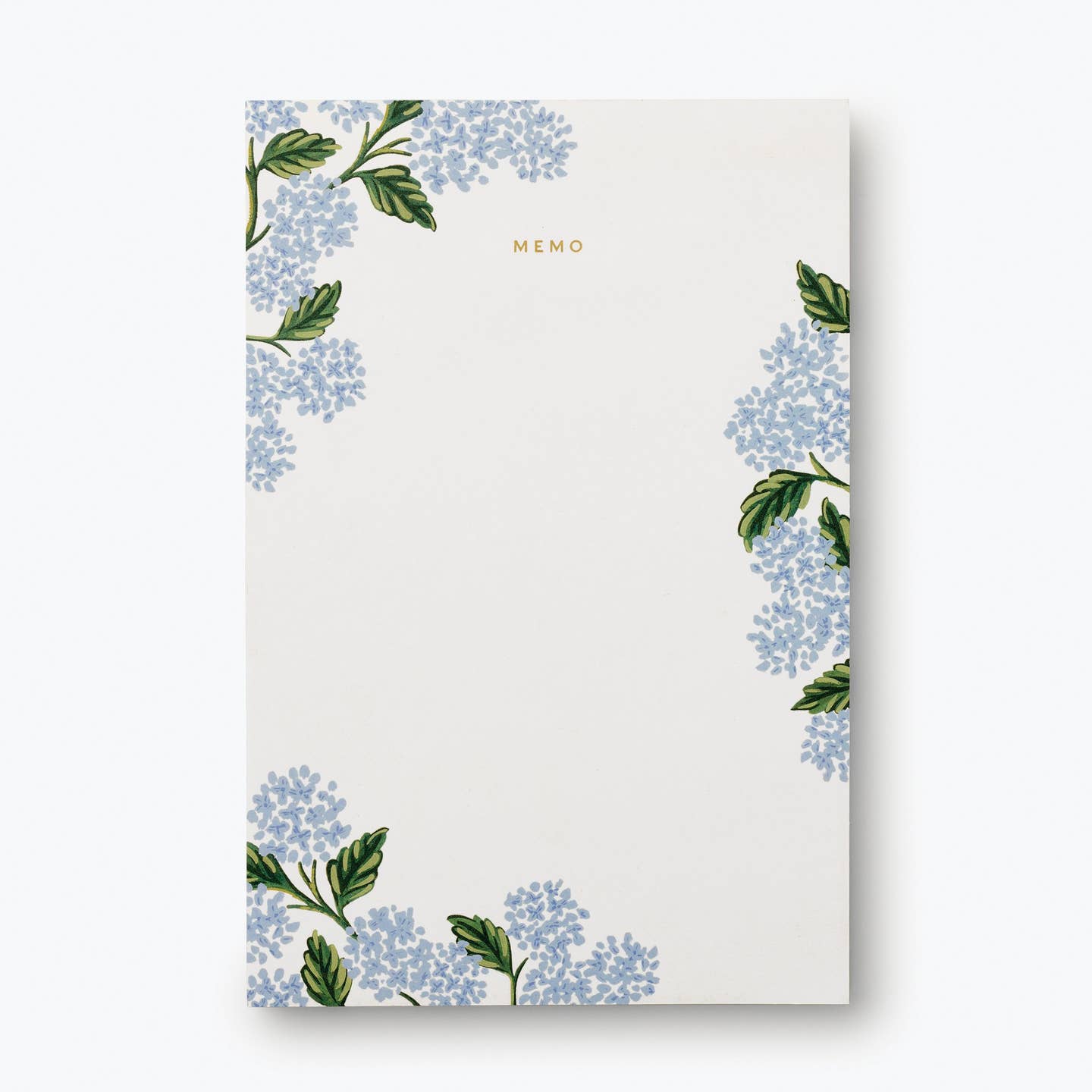 Rifle Paper Co. Hydrangea Memo Notepad, a cream pad with blue hydrangea illustrations in the corners