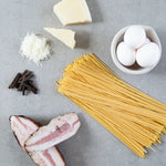 Rivsalt Java Long Pepper beside pasta, parmesan, eggs and pancetta ingredients