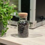 Rivsalt Java Long Pepper glass jar on a kitchen counter beside a plant