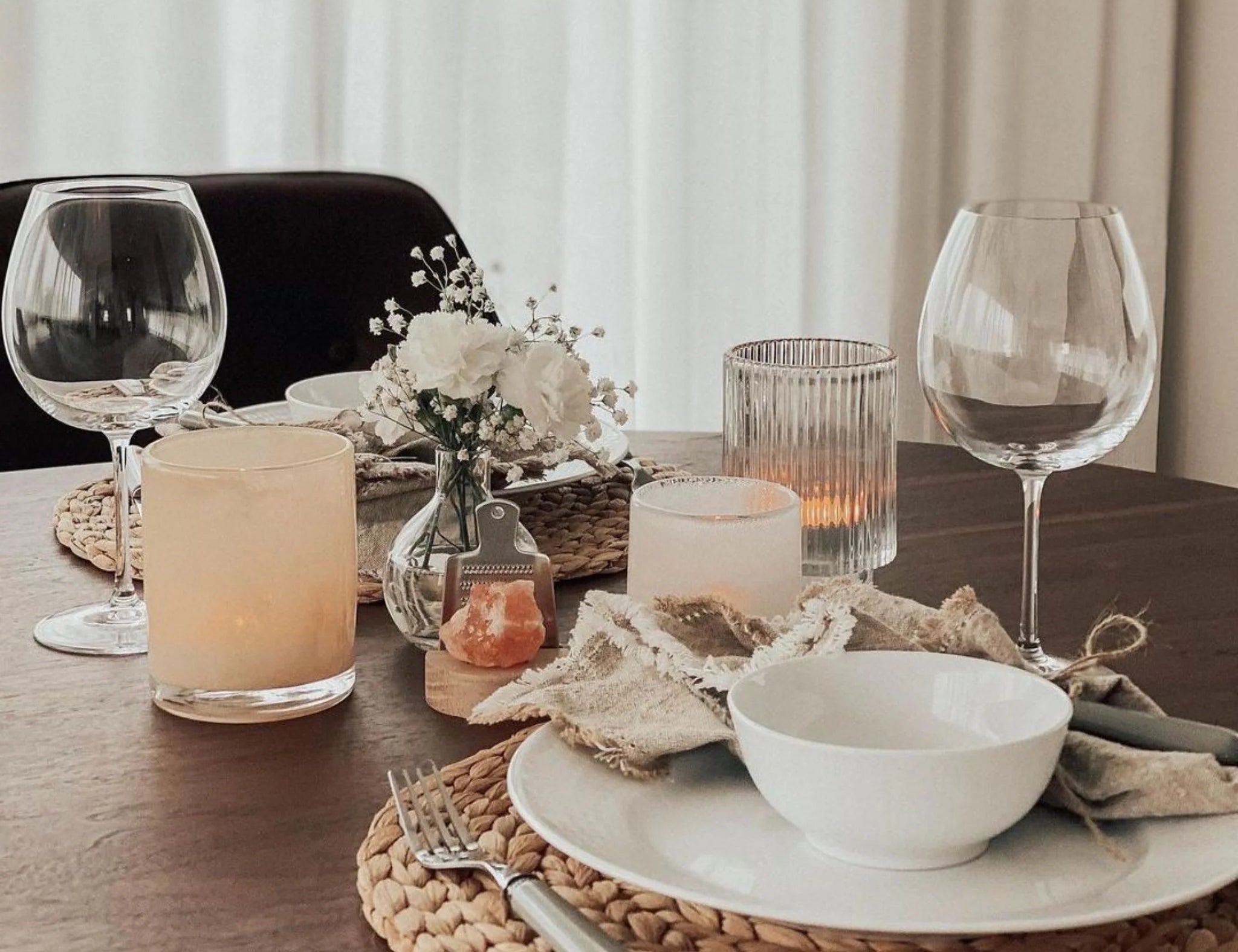 Rivsalt The Original Salt Grater on a dinner table set with wine glasses and a woven placemat
