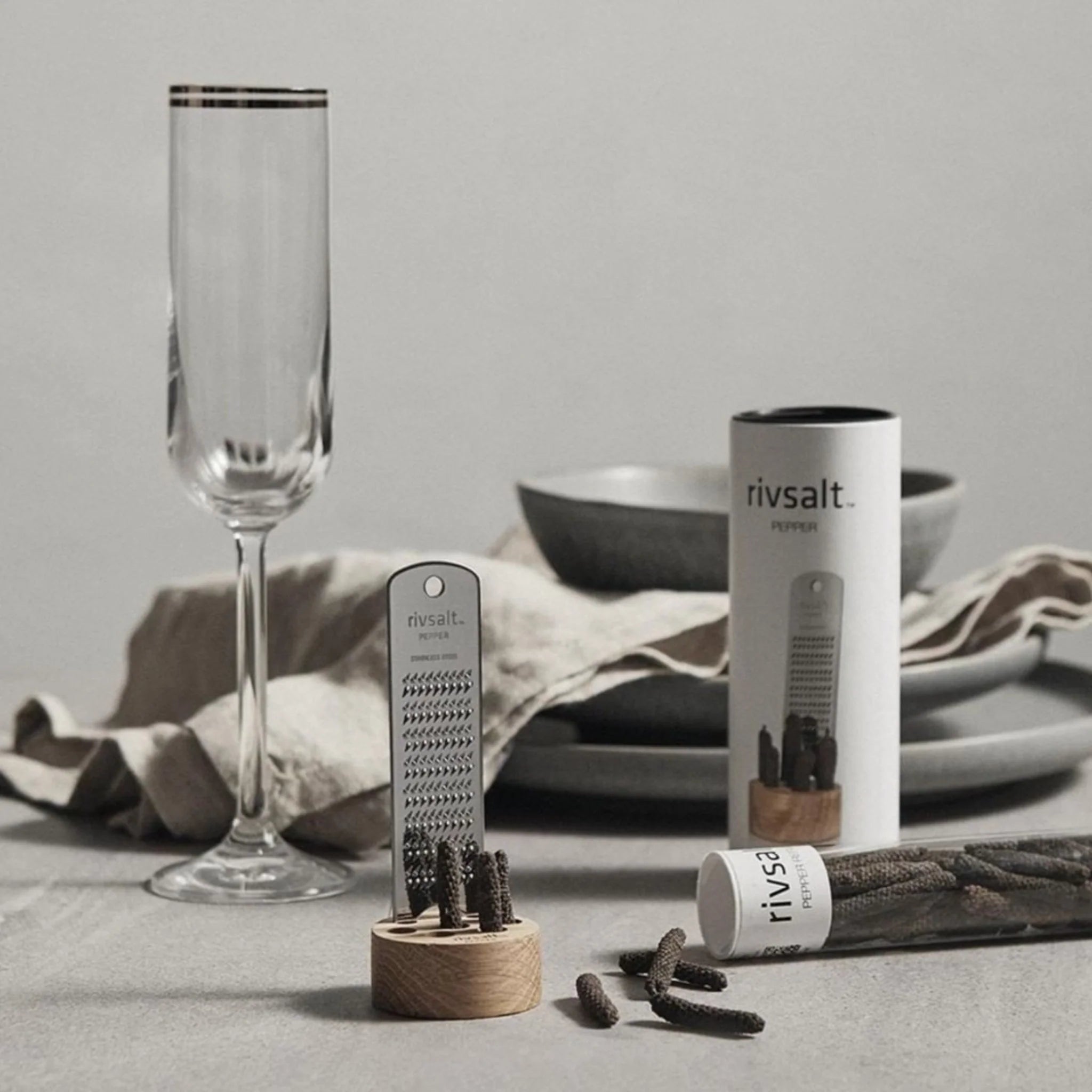 Rivsalt Pepper Stainless Steel Grater on a table set with a champagne flute and linen