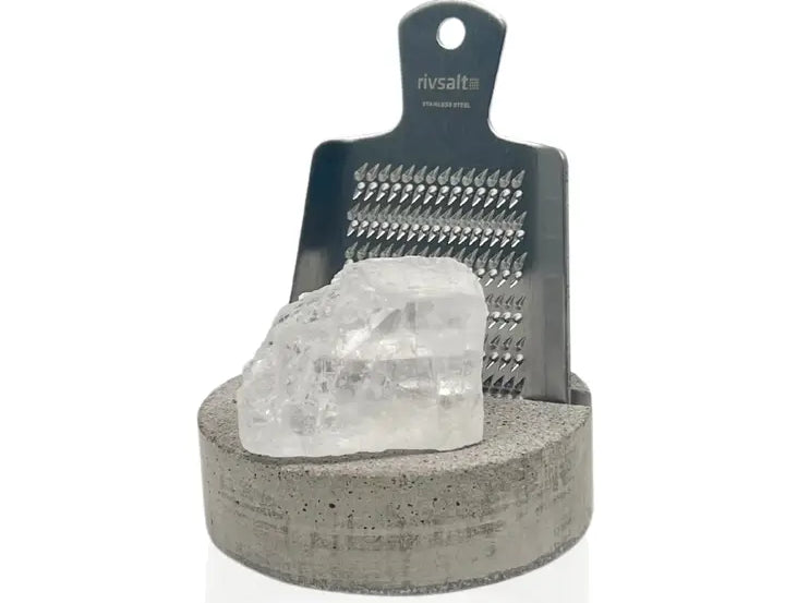 Rivsalt Swedish Concrete Salt Grater, a black grater with a clear rock salt crystal on a concrete base