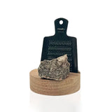 Rivsalt Walnut Salt Grater, a black grater with a gray rock salt crystal on a walnut wood base