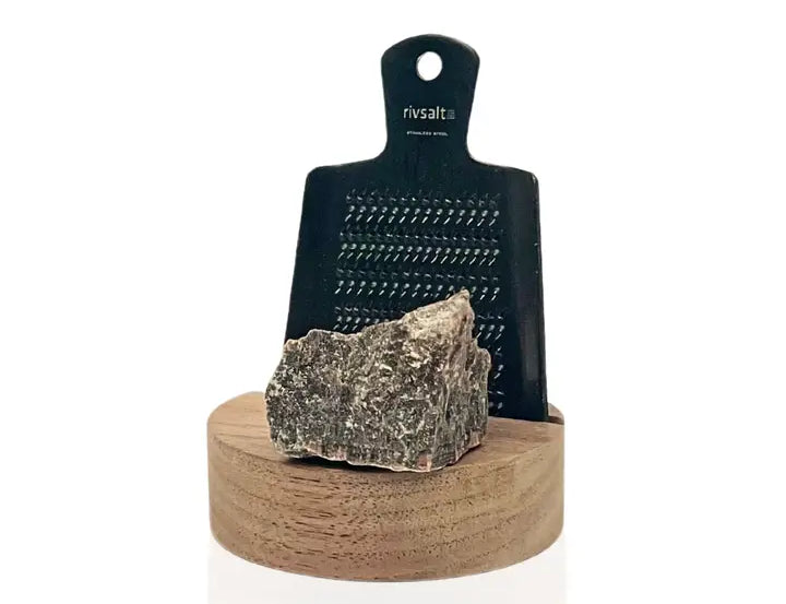 Rivsalt Walnut Salt Grater, a black grater with a gray rock salt crystal on a walnut wood base