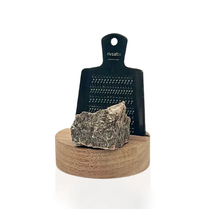 Rivsalt Walnut Salt Grater, a black grater with a gray rock salt crystal on a walnut wood base