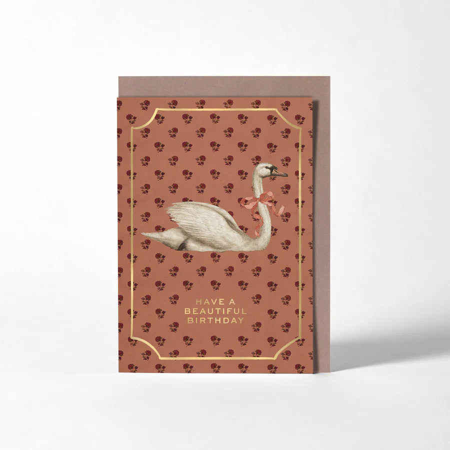 RoomyTown Birthday Swan Greeting Card, a rust red patterned card with a white swan and gold frame