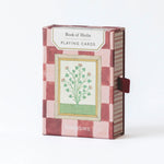 RoomyTown Book of Herbs Playing Cards in a pink and burgundy checkered box with a botanical illustration