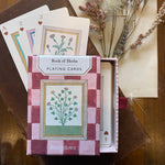 RoomyTown Book of Herbs Playing Cards box on a wooden table with dried flowers and cards