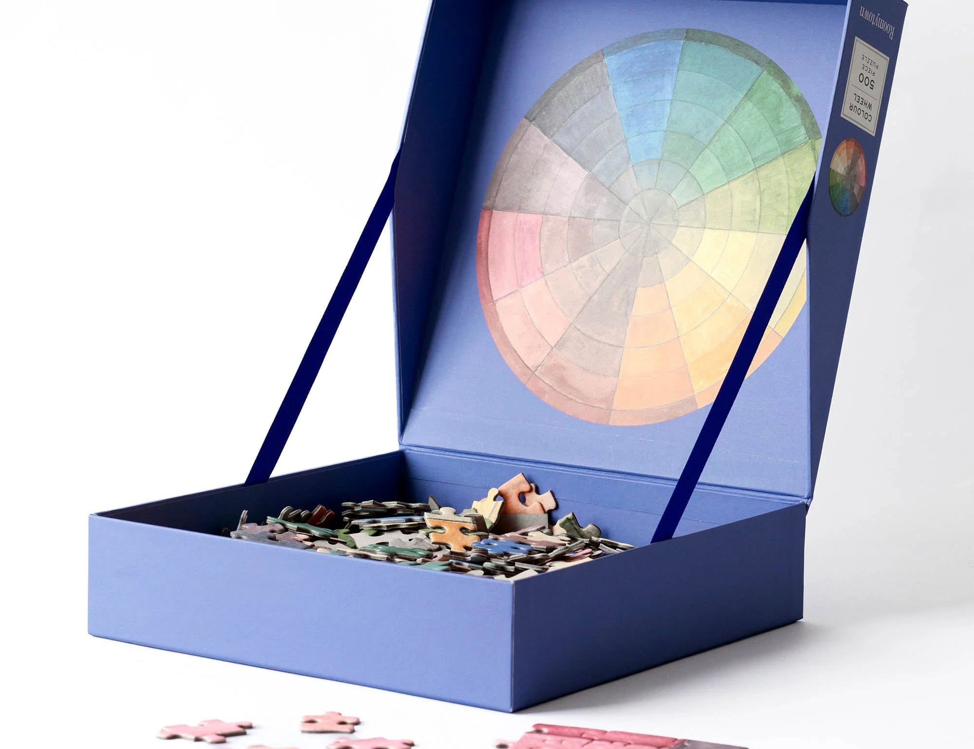 RoomyTown Color Wheel 500-Piece Round Jigsaw Puzzle box open with puzzle pieces spilling out