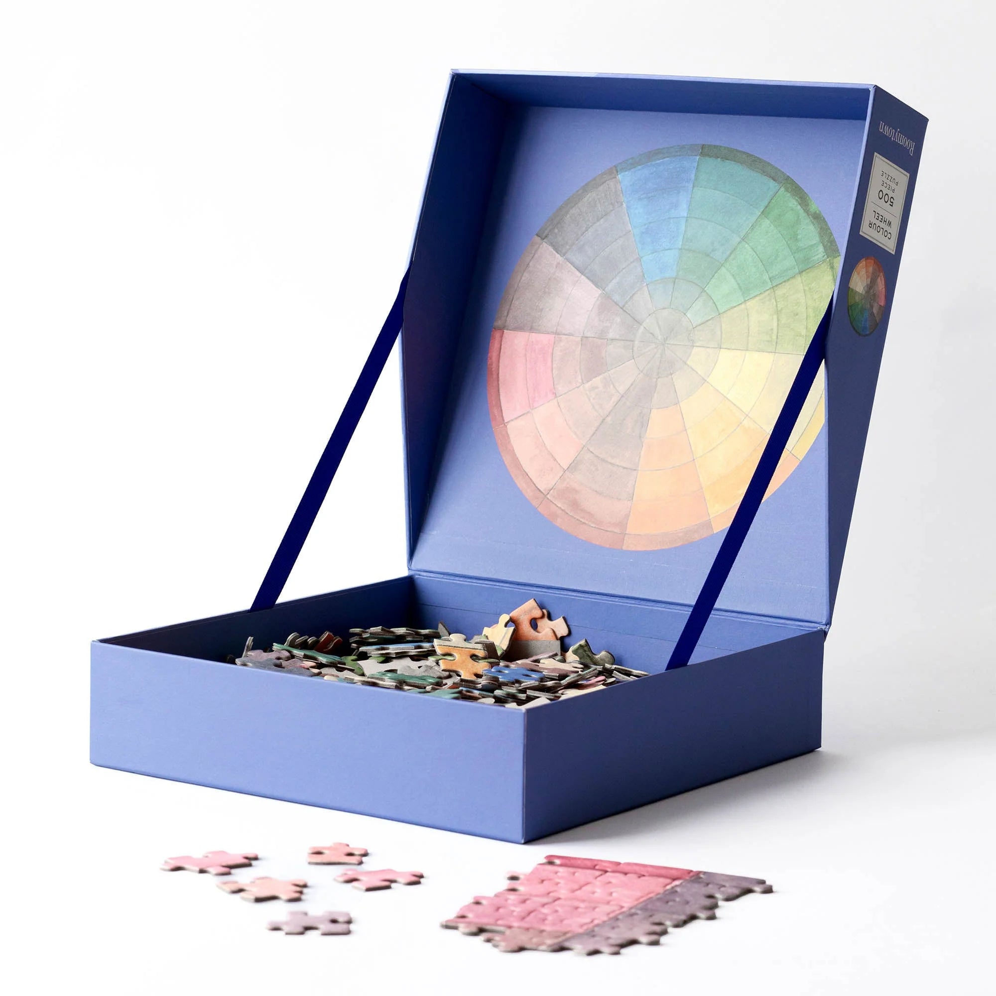 RoomyTown Color Wheel 500-Piece Round Jigsaw Puzzle box open with puzzle pieces spilling out
