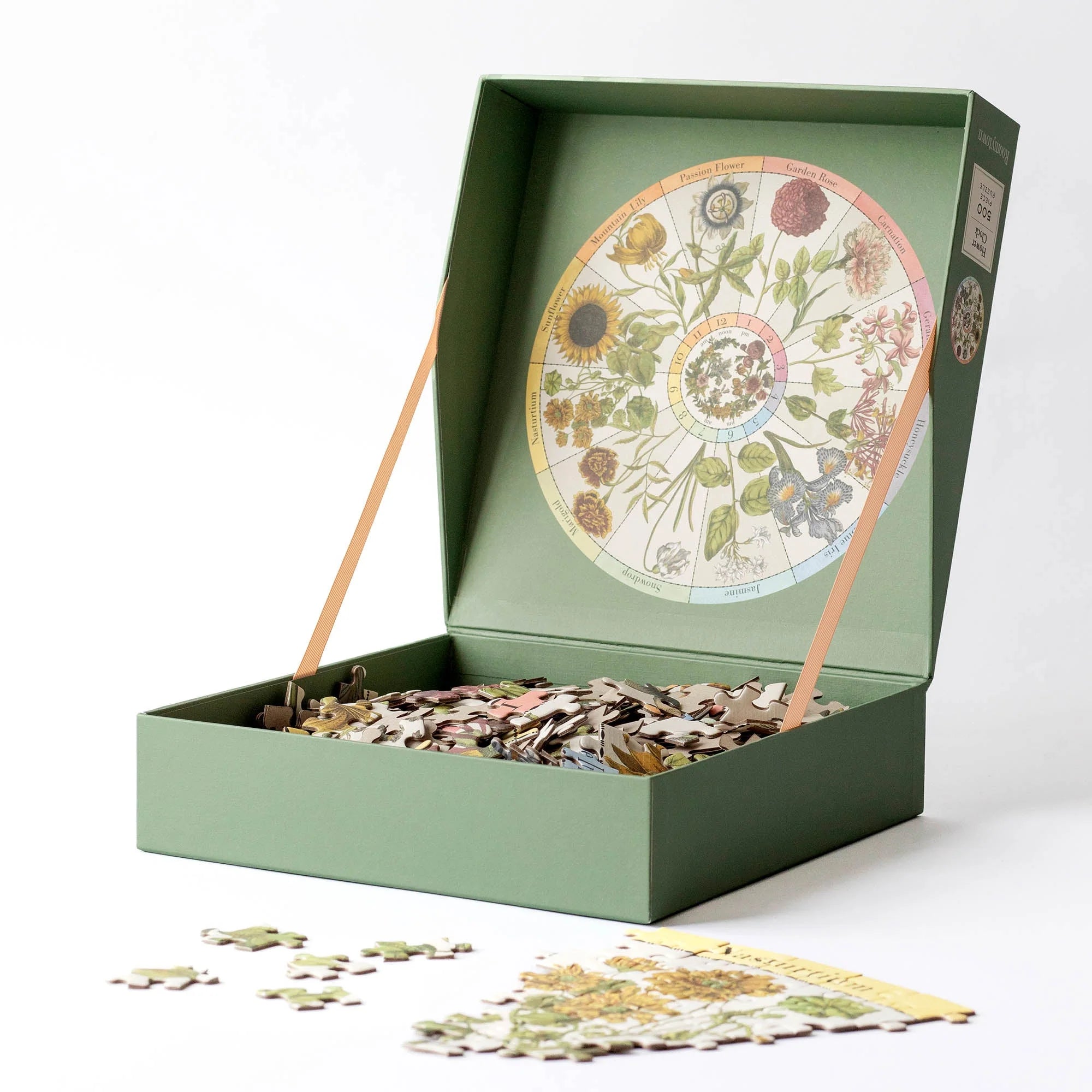 RoomyTown Flower Clock 500-Piece Round Jigsaw Puzzle box open with the puzzle pieces spilling out
