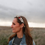 Woman in a denim jacket wearing the Rooted & Wild Adventure Co. Desert Bloom Bandana as a headband in a field