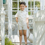 Boy in a cream shirt and shorts wearing a Rylee & Cru Bunny Headband by a garden gate