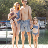 Family of four on a dock, baby in the Rylee & Cru Chocolate Moxie One-Piece, standing together by the water