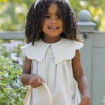 Smiling girl with curly hair holding a Rylee & Cru Easter Basket in Sky Stripe
