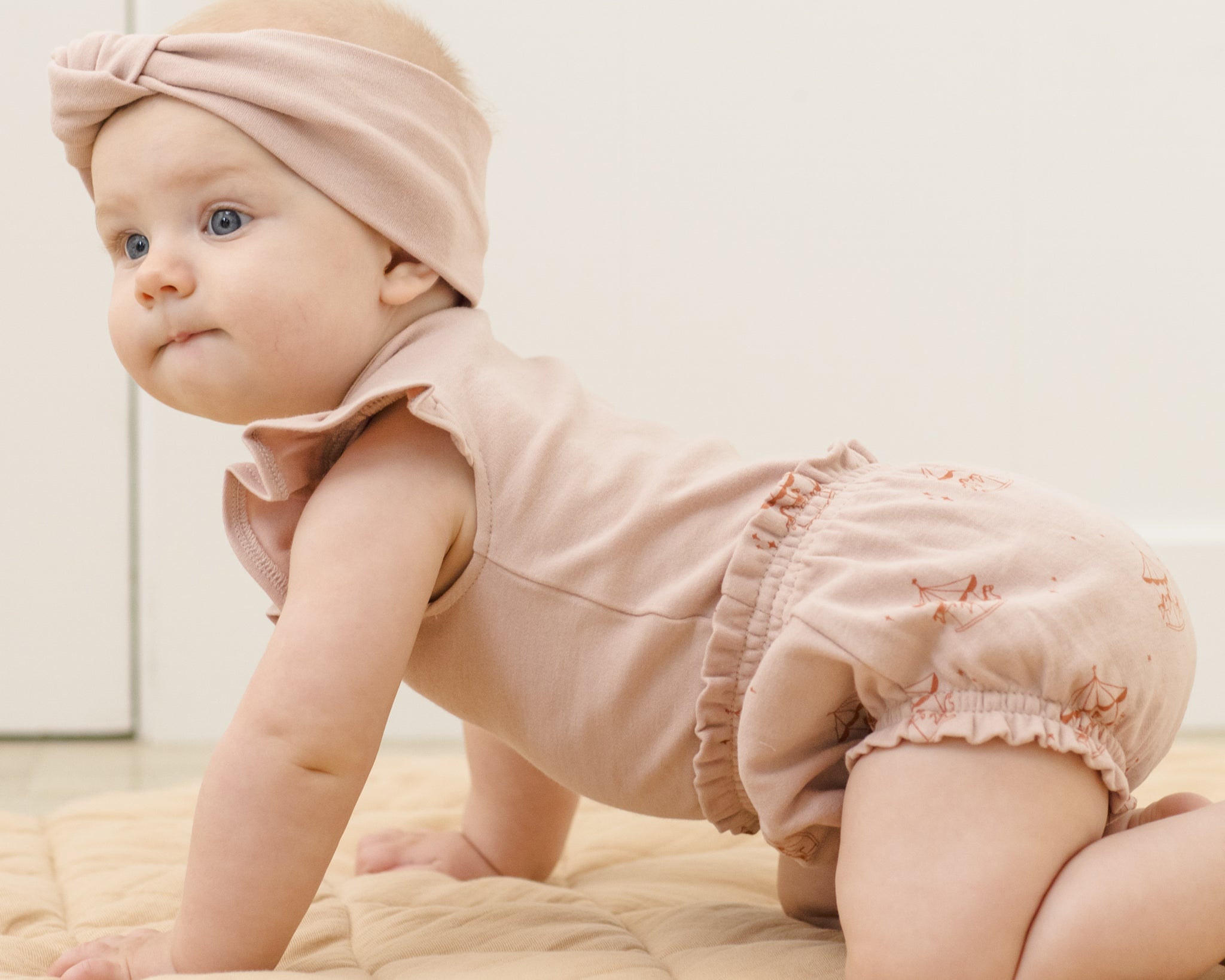 Baby crawling in the Rylee & Cru Flutter Sleeve Bodysuit in Blush with matching bloomers and headband