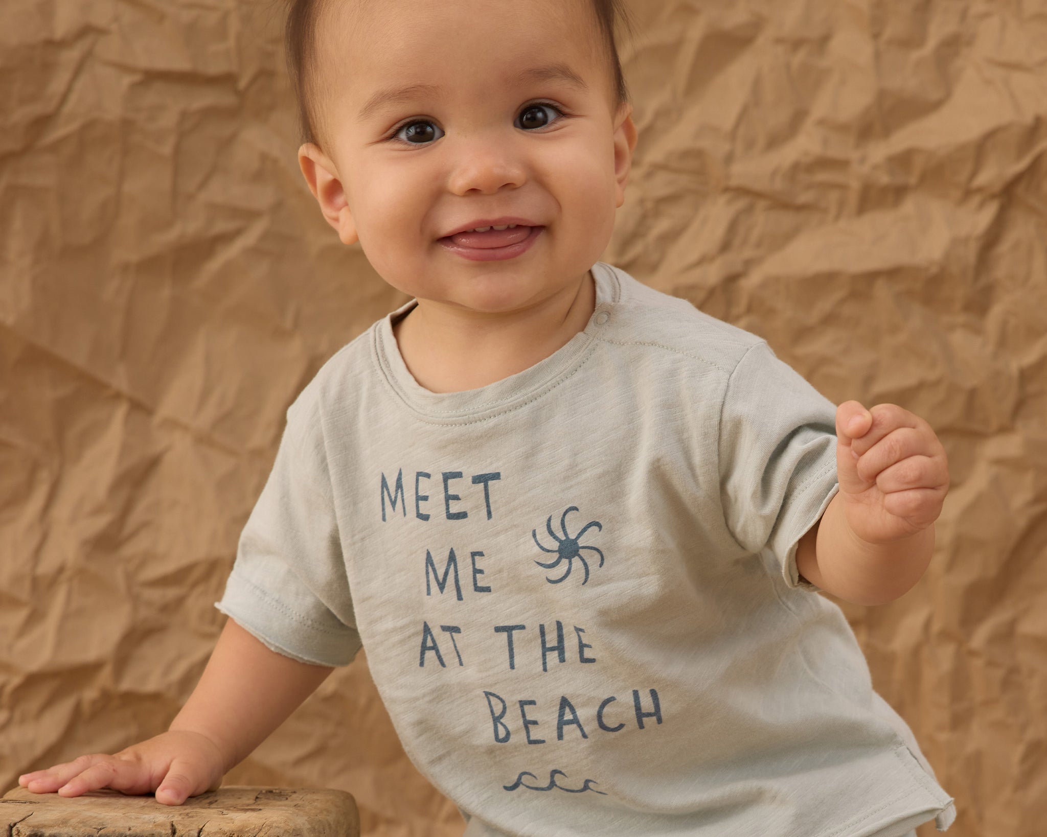 Smiling baby in a Meet Me at the Beach tee and Rylee & Cru Paneled Boardshort in Marine