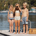 Three kids on a lake dock, the boy wearing the Rylee & Cru Paneled Boardshort in Marine