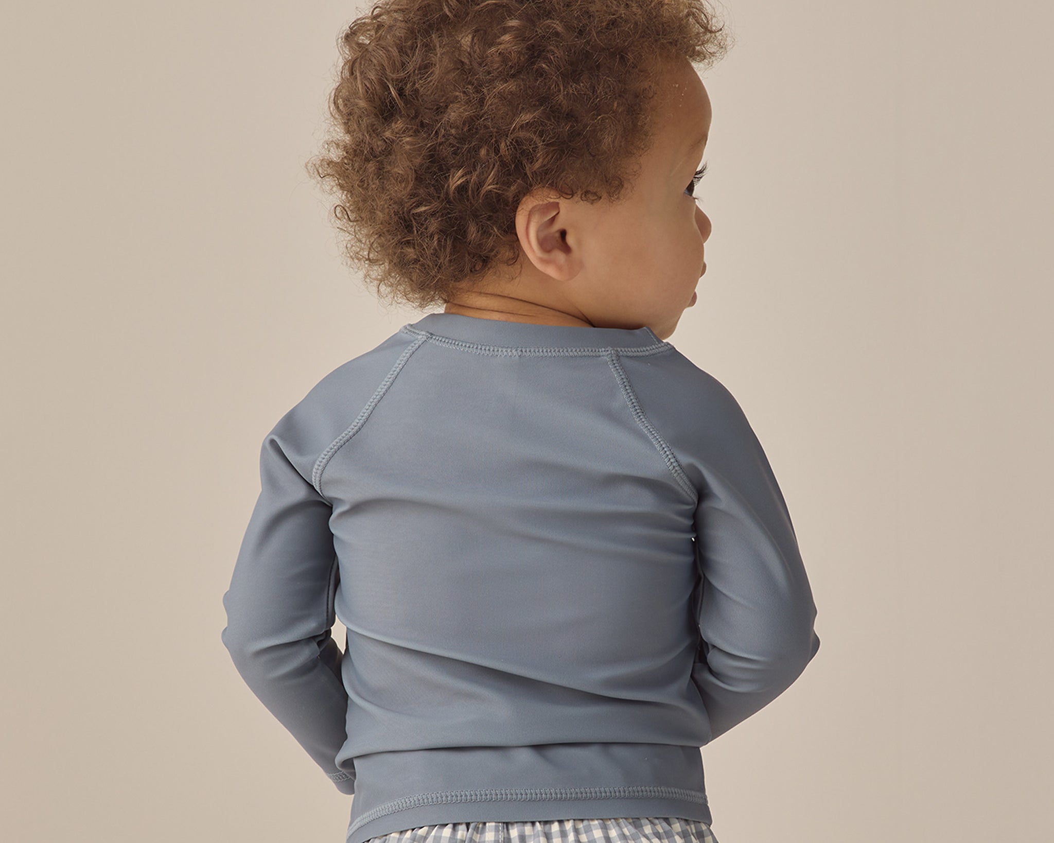 Back view of a toddler wearing the Rylee & Cru Rashguard Long Sleeve in Ocean