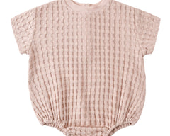 Rylee & Cru Relaxed Bubble Romper in Blush, a pale pink waffle-knit baby romper, laid flat
