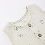 Close-up of the rocket, planet and star print and wooden buttons on the Rylee & Cru Romper in Space