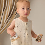Toddler holding wooden toy cars while wearing the Rylee & Cru Romper in Space