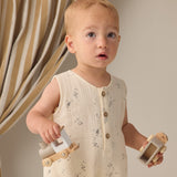 Toddler holding wooden toy cars while wearing the Rylee & Cru Romper in Space
