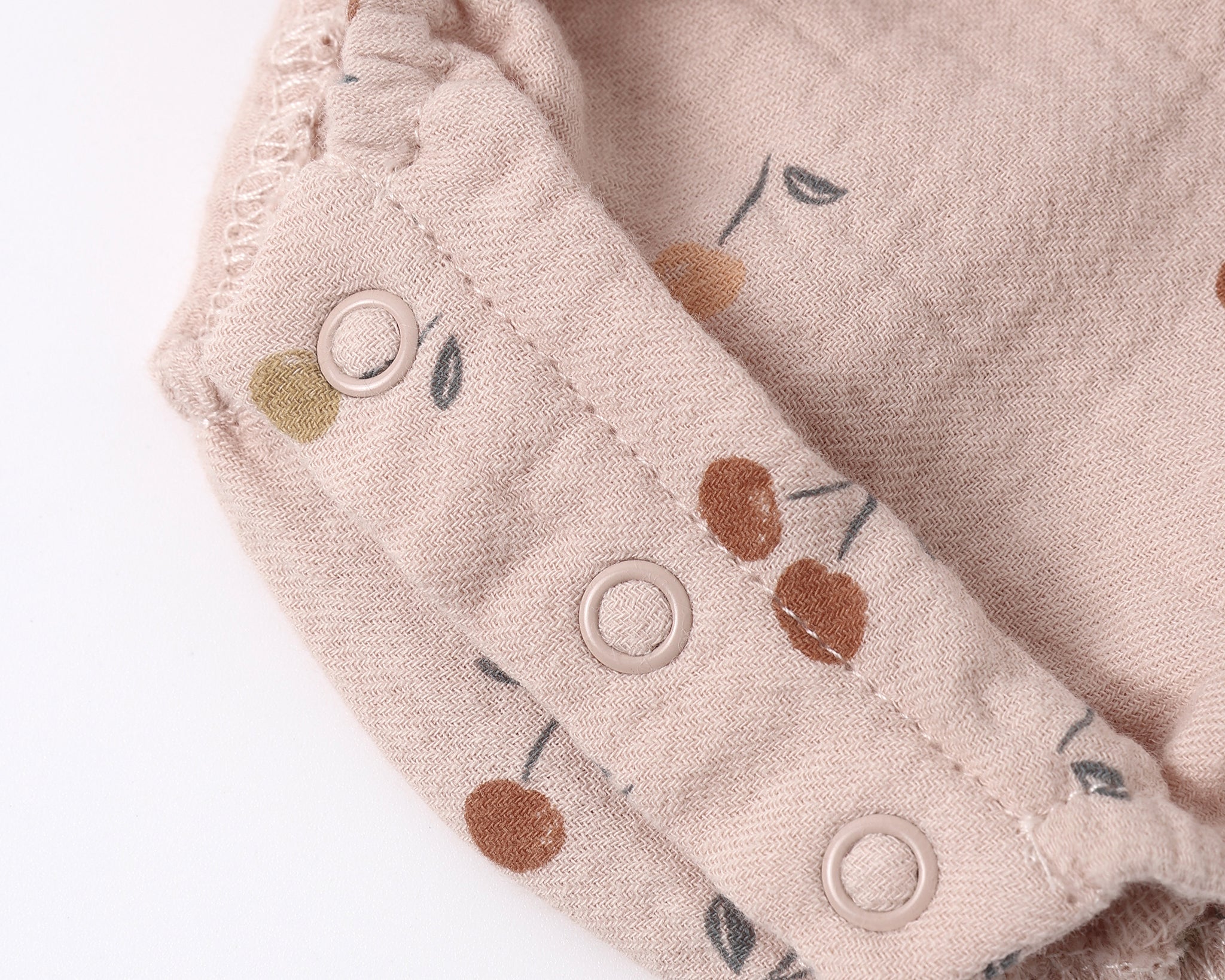 Close-up of the snap closures and cherry print on the Rylee & Cru Ruffle Romper in Cherries