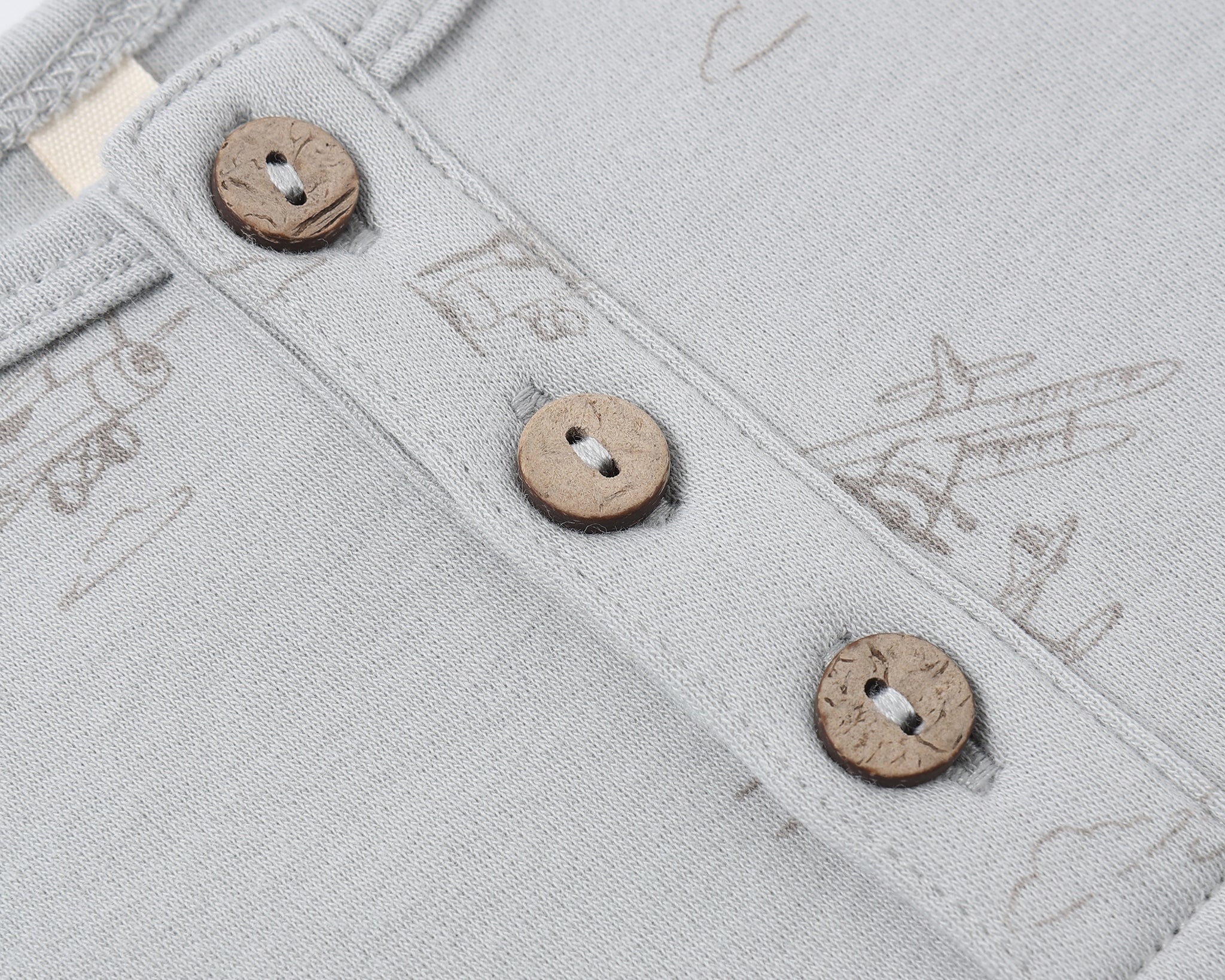 Close-up of the wooden buttons and airplane print on the Rylee & Cru Short Sleeve One-Piece in Airplanes