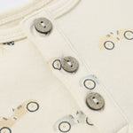 Close-up of the wooden buttons and race car print on the Rylee & Cru Short Sleeve One-Piece in Race Car
