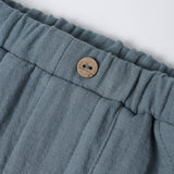 Close-up of the wooden button and elastic waistband on the Rylee & Cru Utility Short in Ocean