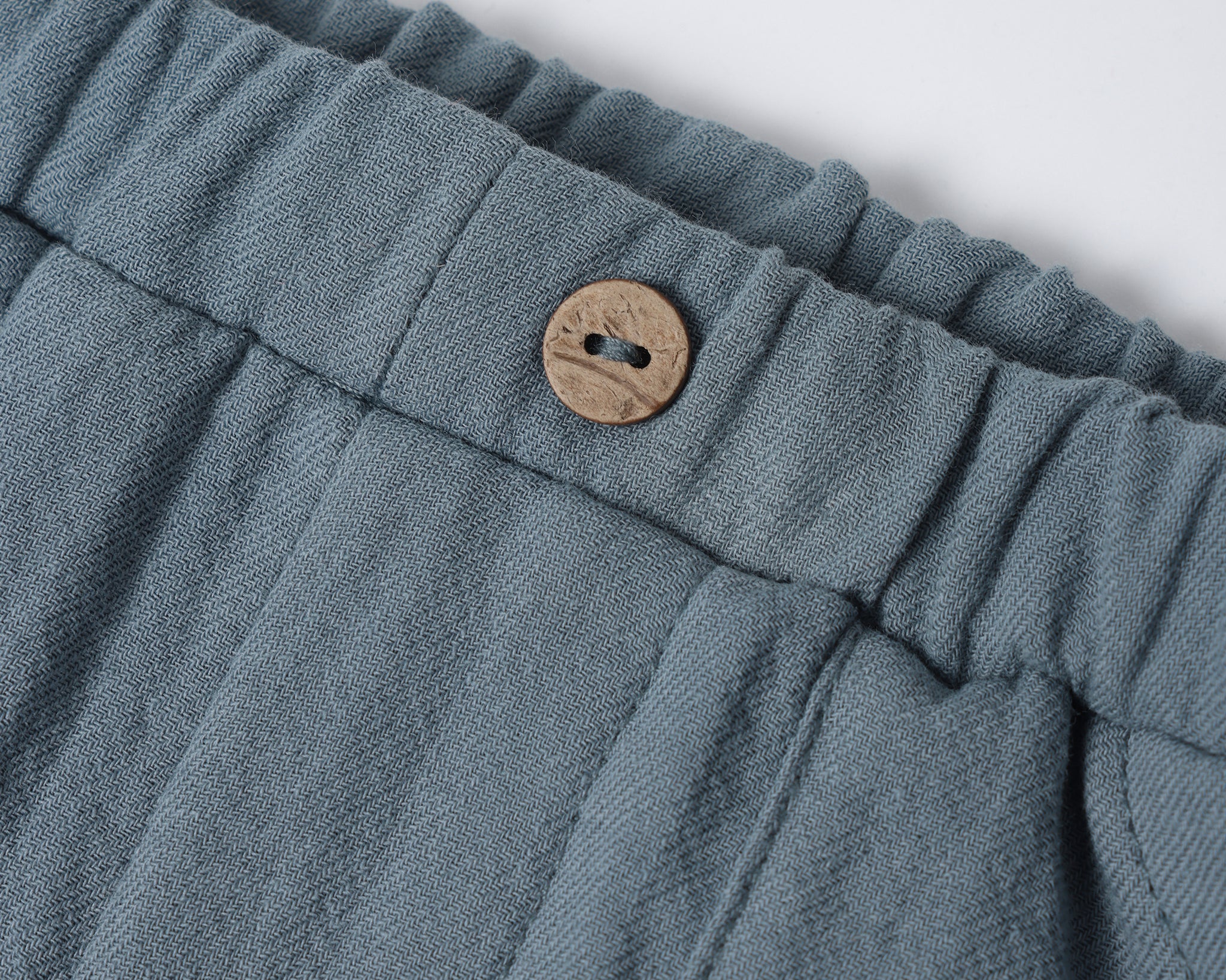 Close-up of the wooden button and elastic waistband on the Rylee & Cru Utility Short in Ocean