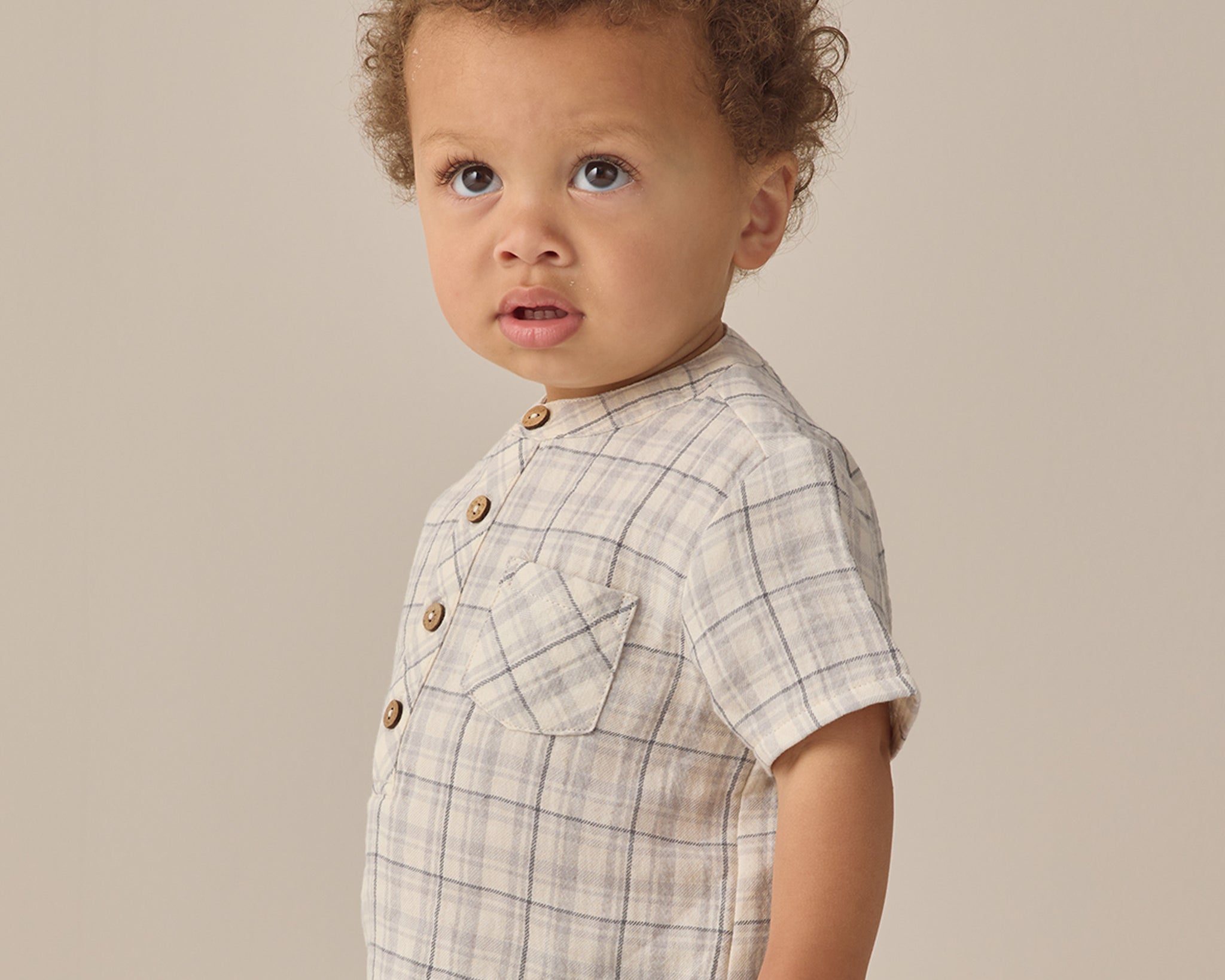 Toddler with curly hair in a plaid shirt and Rylee & Cru Utility Short, looking to the side