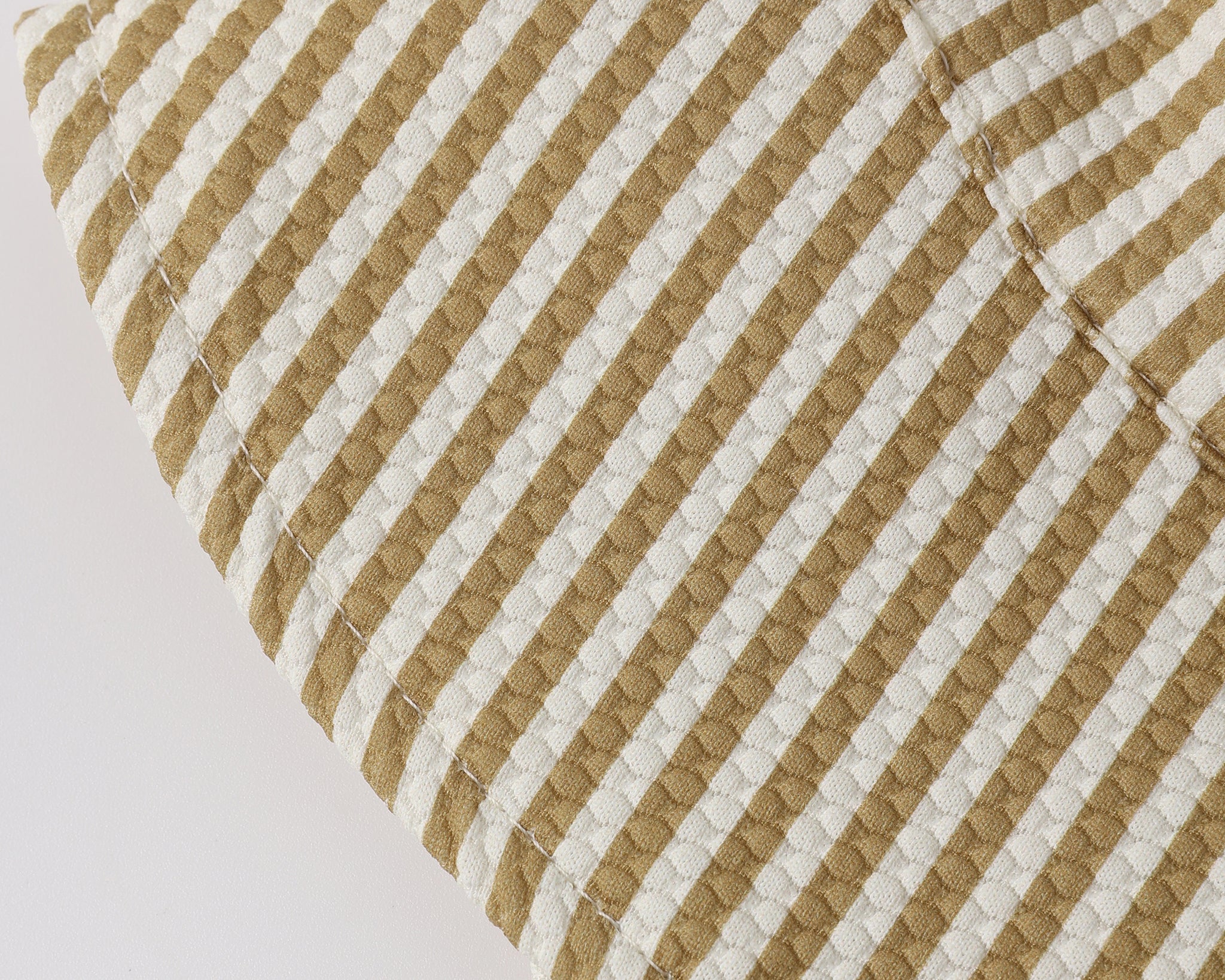 Close-up of the mustard and cream seersucker stripe fabric on the Rylee & Cru Youth Bucket Hat in Honey Stripe