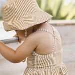 Toddler wearing the Rylee & Cru Youth Bucket Hat in Honey Stripe outdoors by a pool