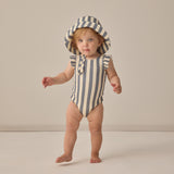 Toddler standing in a striped swimsuit wearing the Rylee & Cru Youth Bucket Hat in Retro Stripe Ocean