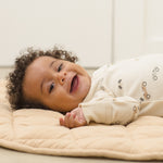 Laughing baby lying on a quilt wearing the Rylee & Cru Zip Longsleeve Sleeper in Race Car