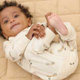 Baby lying on a quilt wearing the Rylee & Cru Zip Longsleeve Sleeper in Race Car, hands together