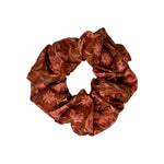 Satin scrunchie in Ember Floral, a satin hair tie printed with warm red and pink flowers, on a white background.