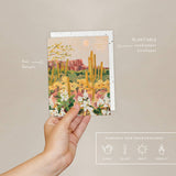 Hand holding the Seedlings Desert Moonlight card with its plantable seed paper envelope and instructions