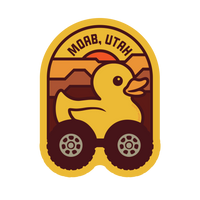 Simply Moab Jeep Duck Pin, yellow rubber duck on off road tires under an arch of orange mesas reading MOAB, UTAH