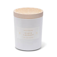 Skeem Black Currant Candle in a white glass jar with a natural wood lid