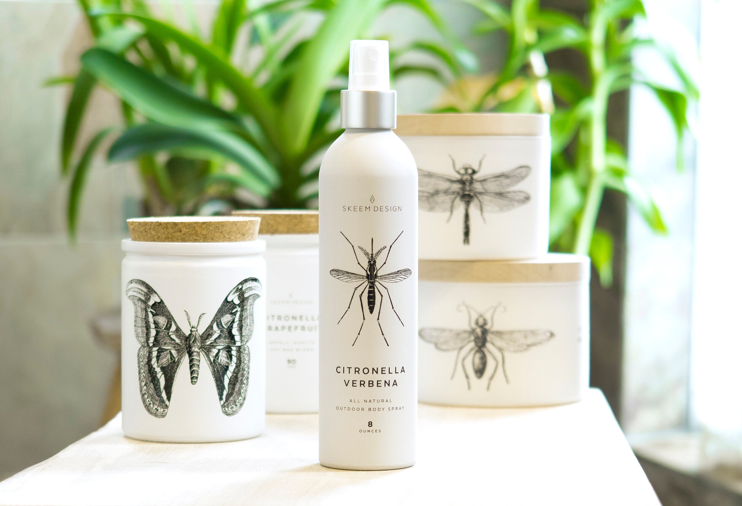 Skeem Citronella Verbena Outdoor Body Spray with matching citronella candles and plants
