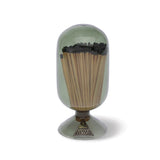 Skeem Match Cloche in Olive, a green glass dome filled with long matches on a footed base