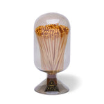 Skeem Match Cloche in Smoke, a gray glass dome filled with long matches on a footed base