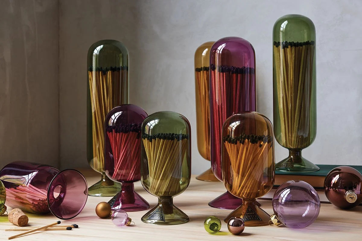 Skeem Match Cloches in olive, amber, plum and violet on a table with matches