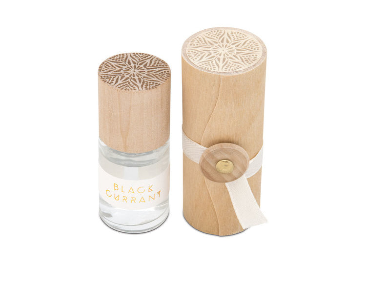 Skeem Print Block Perfume in Black Currant, a small rollerball bottle beside its carved wooden print block case